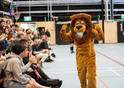 Law Lion mascot walking along the sideline of the court getting the crowd excited