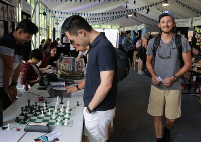 Students studying chess board at stall