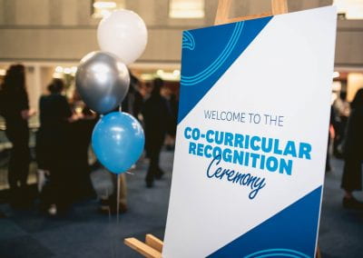 Balloons and sign reading "Welcome to the Co-Curricular Recognition Ceremony"