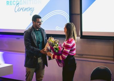 Event speaker being presented with bouquet of flowers